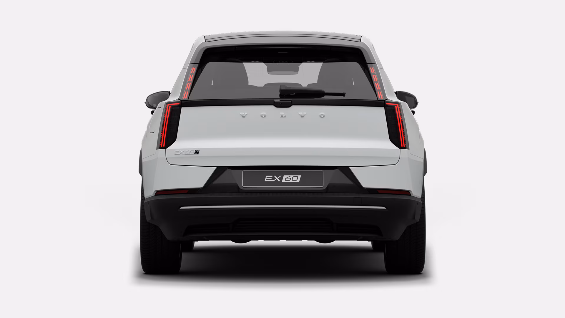 Вид сзади на белый Volvo EX60 с современным дизайном задних фонарей и фирменной символикой Volvo.