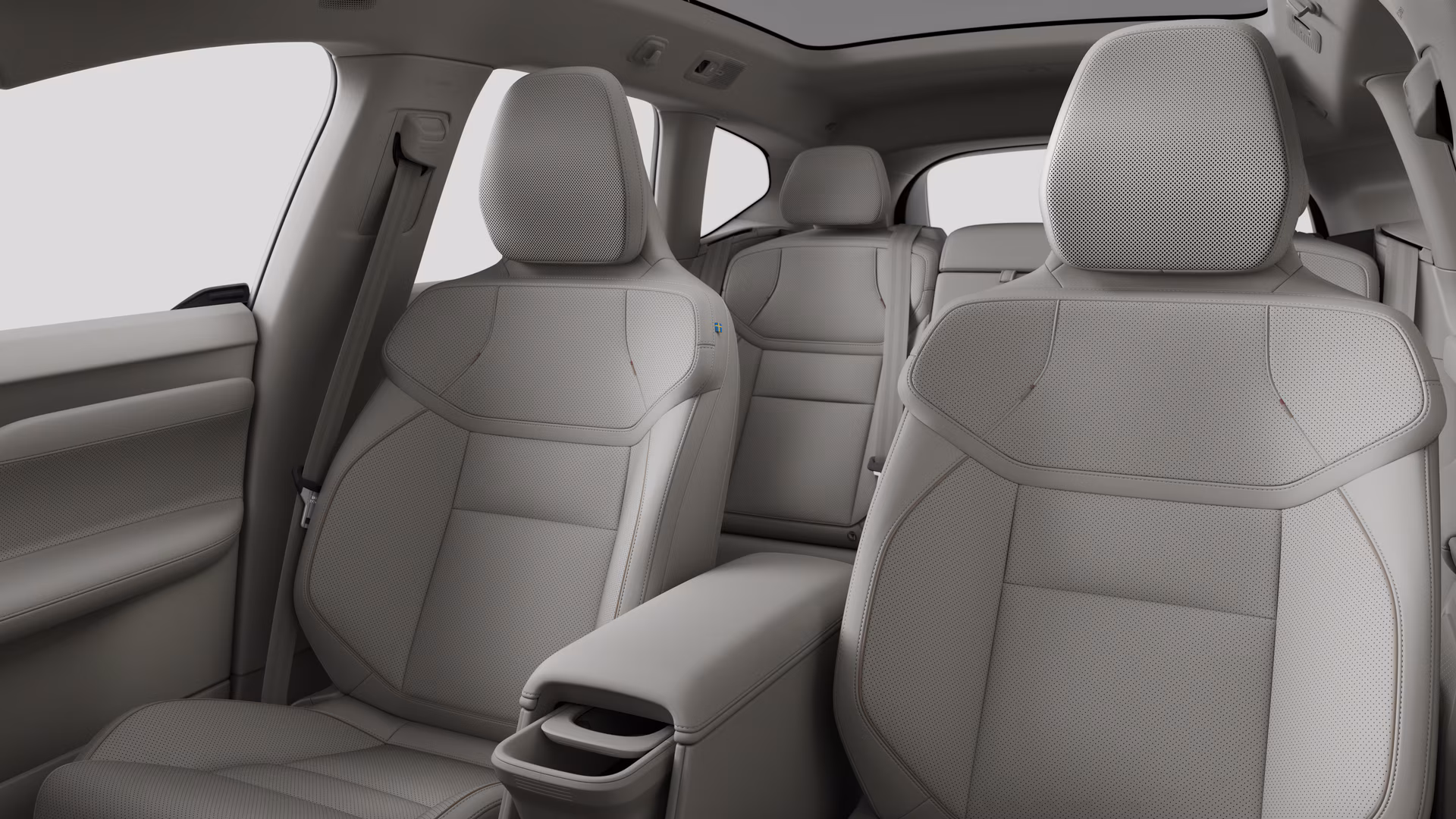 Салон автомобиля Volvo с задними пассажирскими сиденьями и центральной консолью на простом фоне студии.
