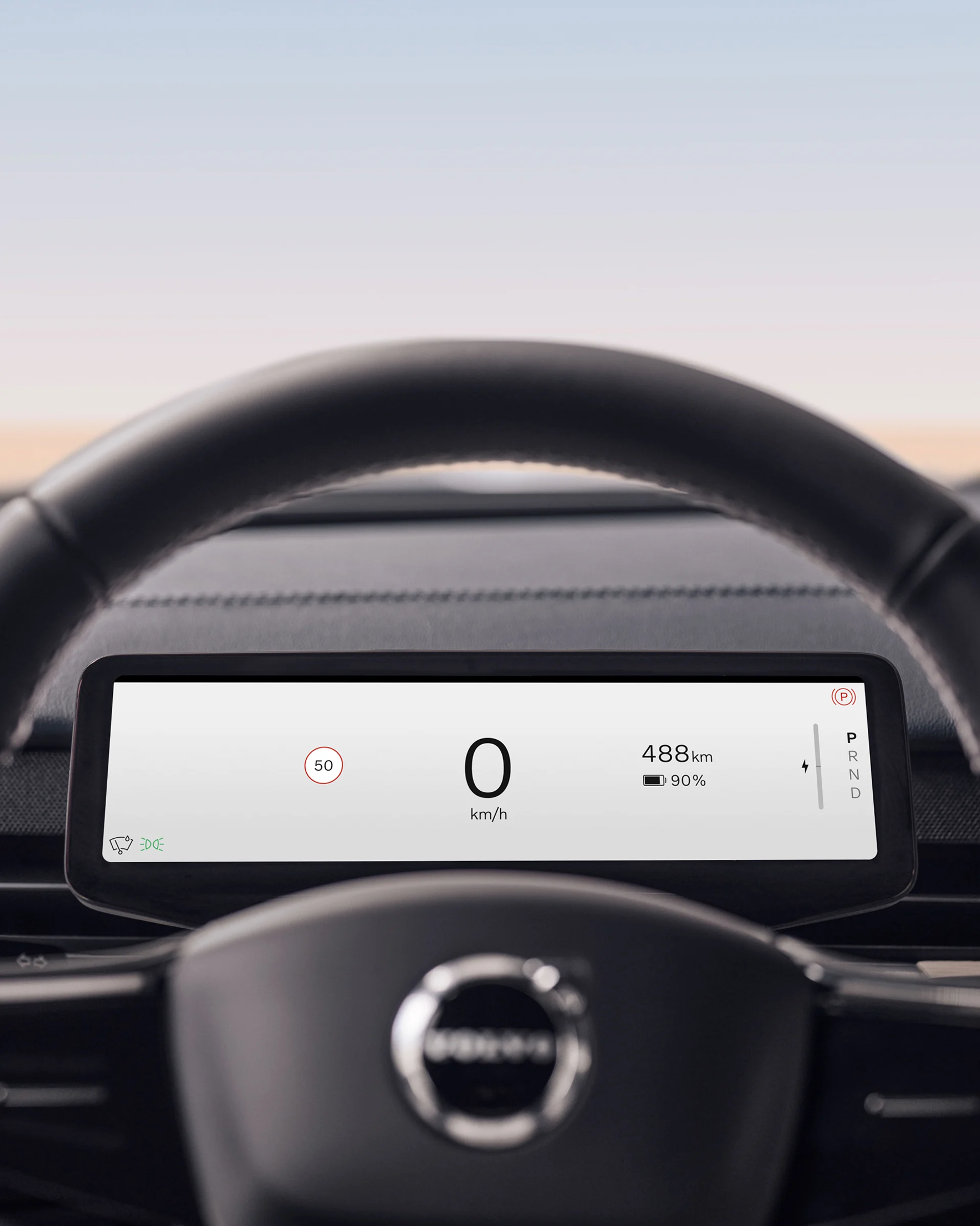 Крупный план рулевого колеса Volvo EX90 с сенсорным экраном на заднем плане.