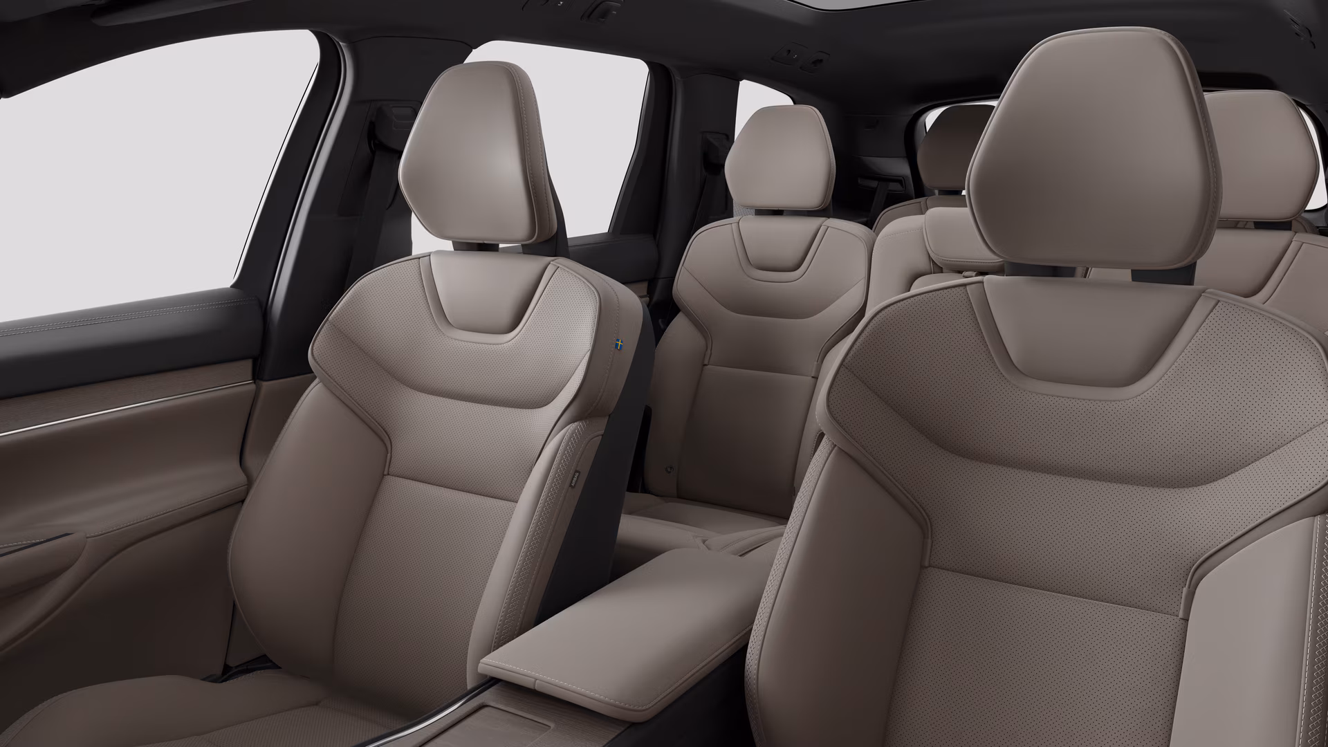 Салон автомобиля Volvo с задними пассажирскими сиденьями и центральной консолью на простом фоне студии.