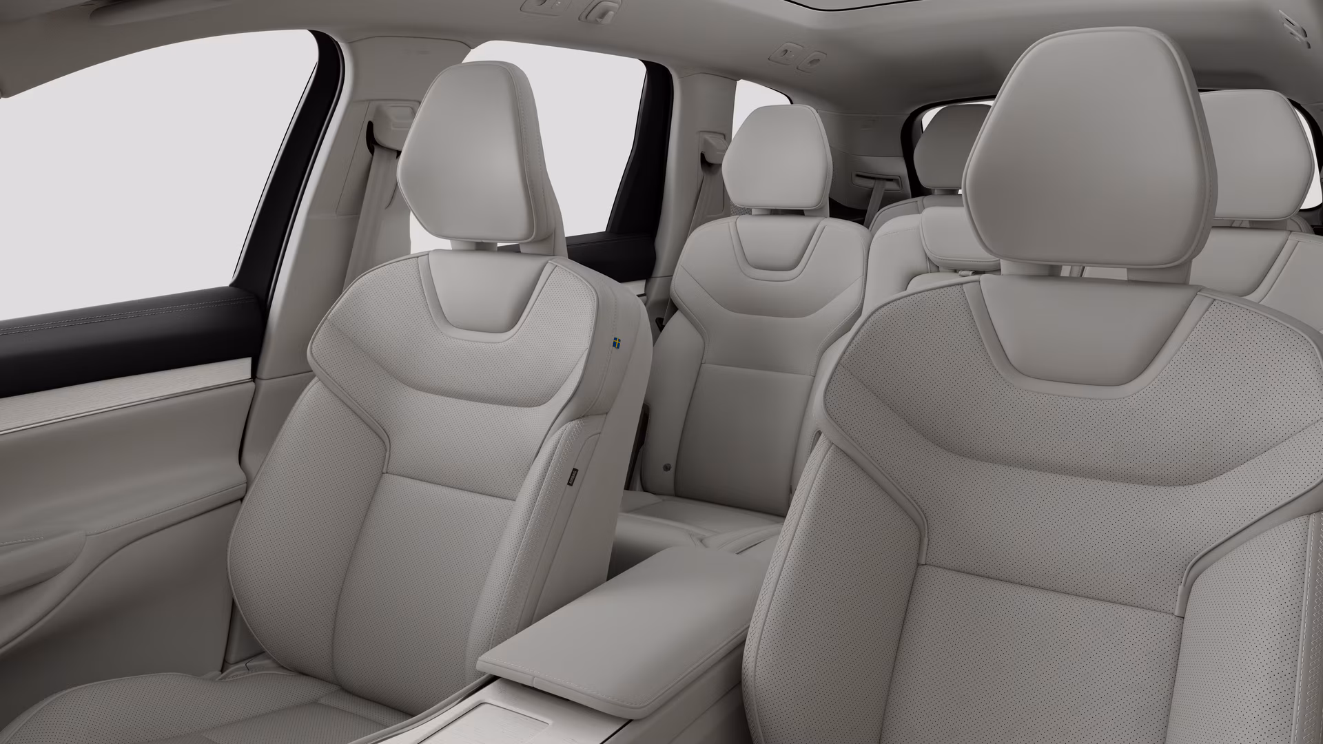 Салон автомобиля Volvo с задними пассажирскими сиденьями и центральной консолью на простом фоне студии.