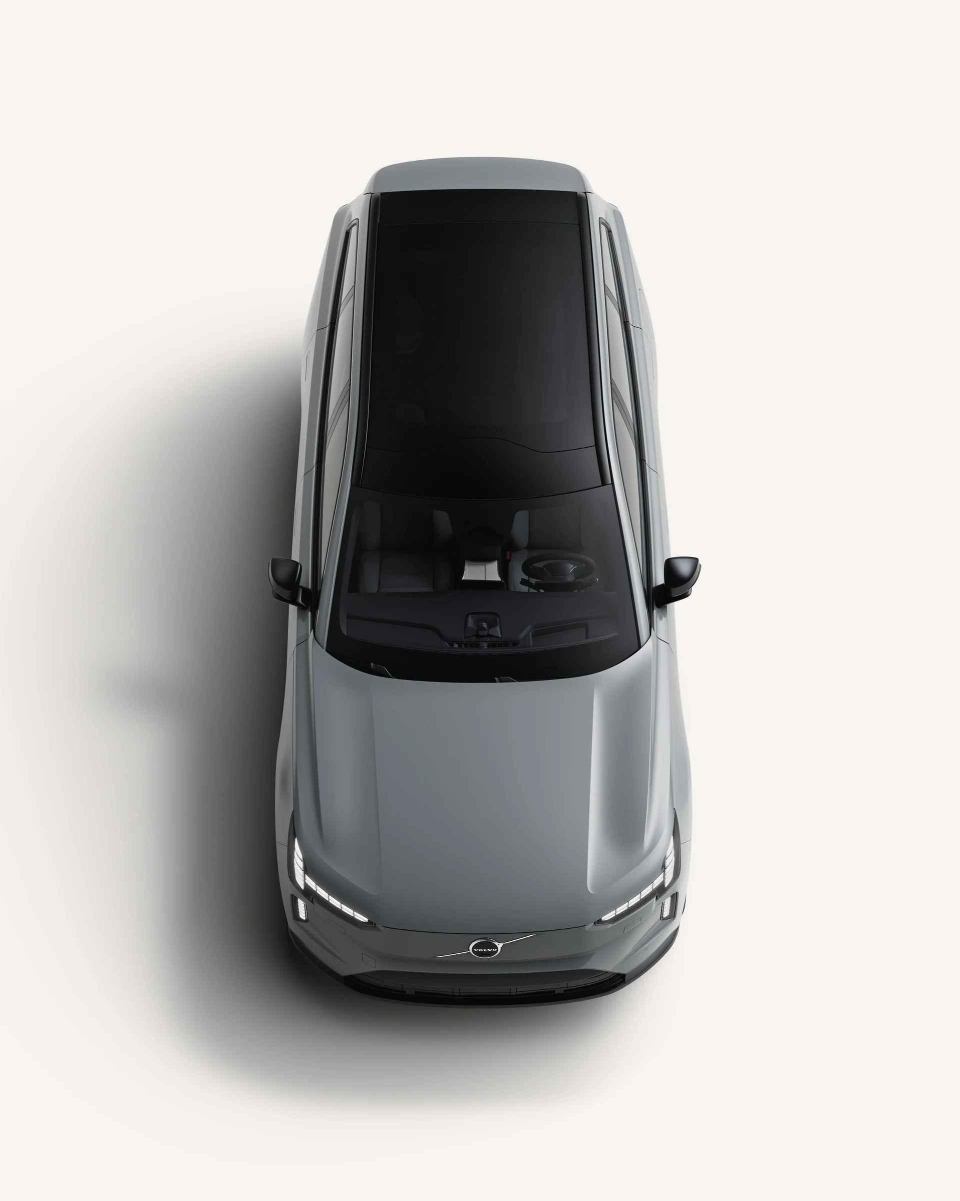 Вид сверху на Volvo EX90 с крышей в белой студии.