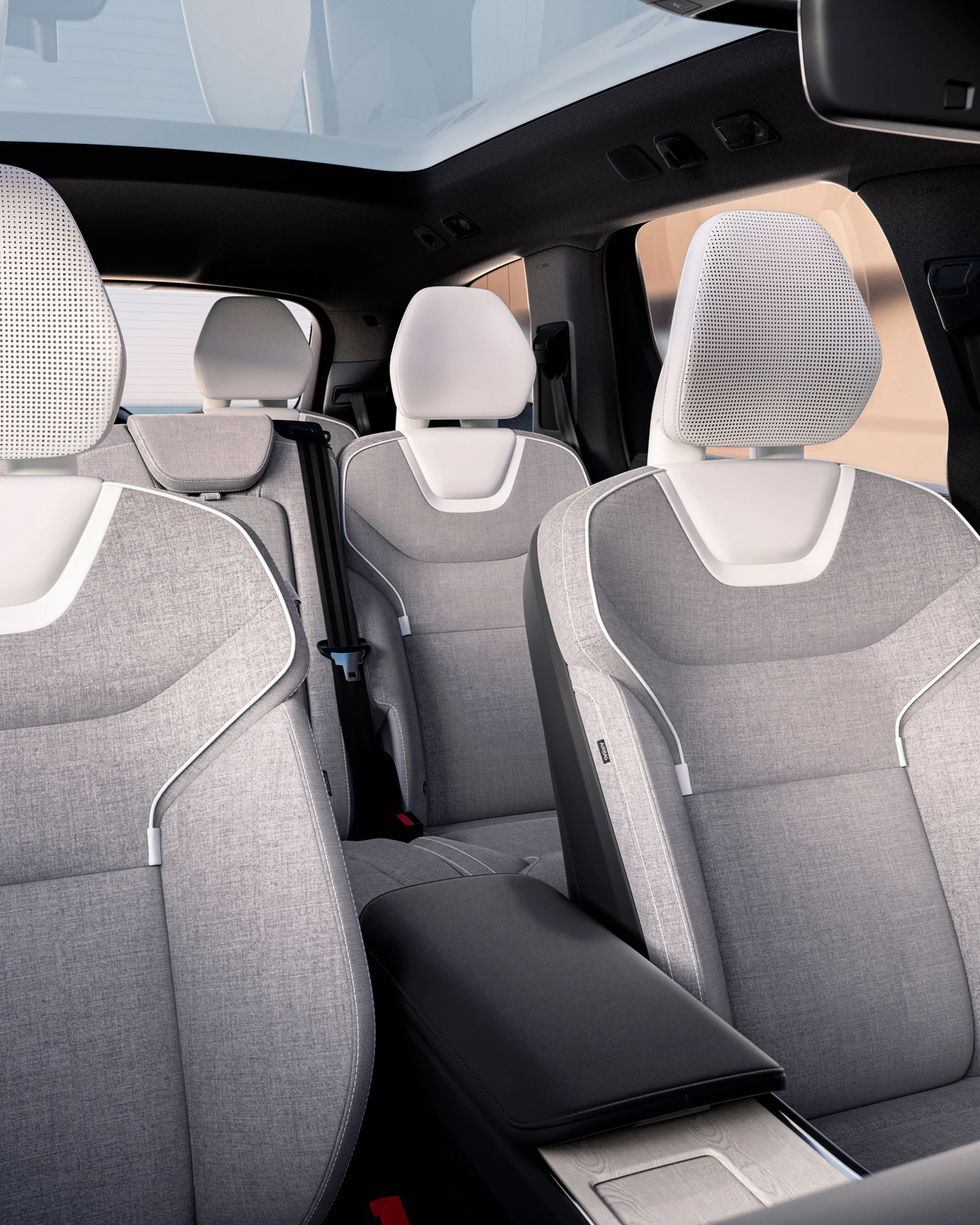 Салон Volvo EX90 с перфорированными передними сиденьями и просторными задними сиденьями.