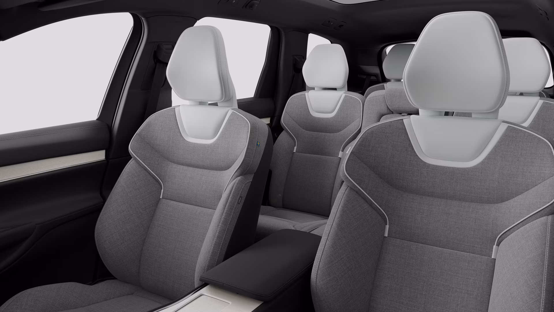 Салон автомобиля Volvo с задними пассажирскими сиденьями и центральной консолью на простом фоне студии.
