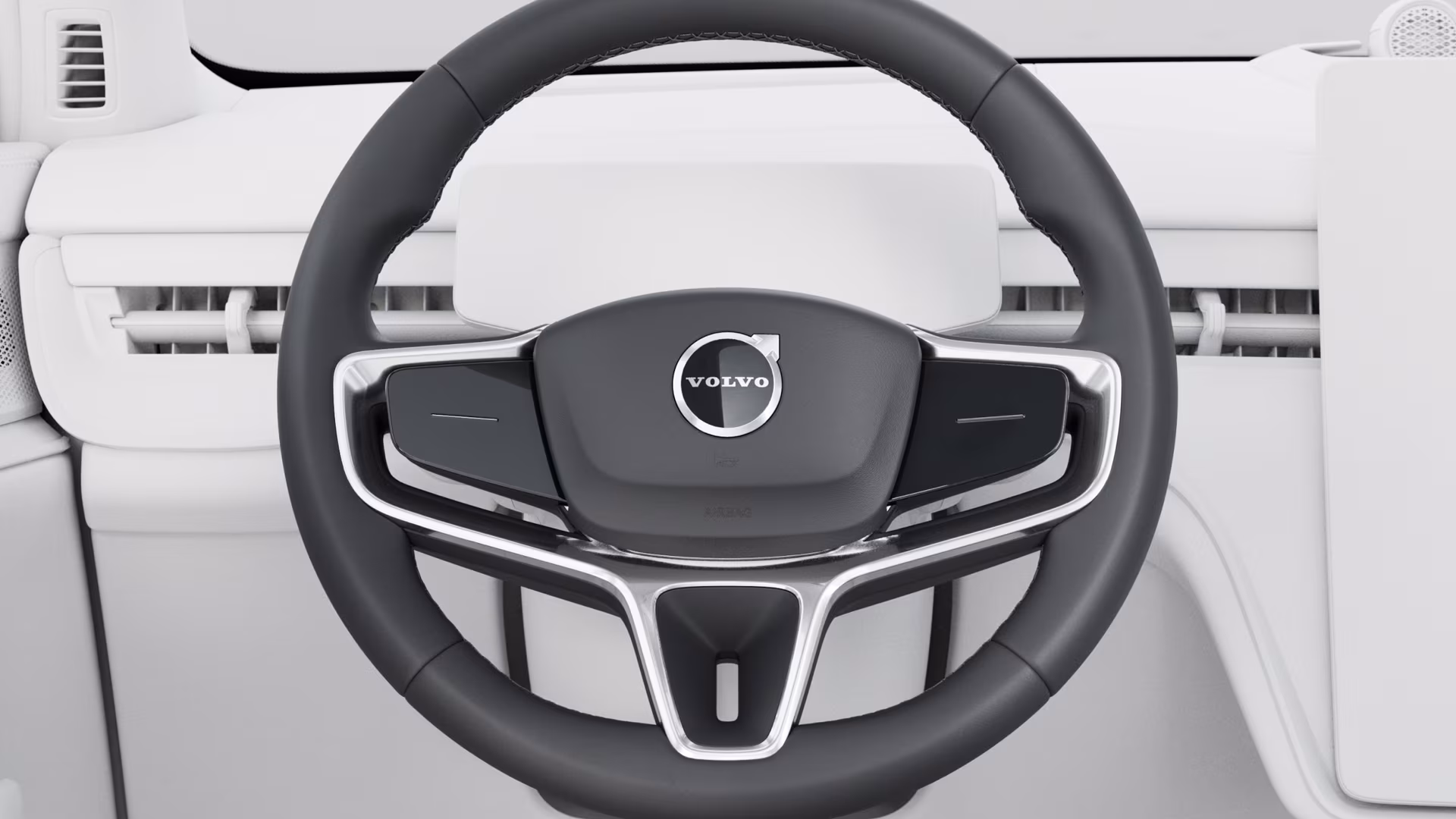 Крупный план рулевого колеса Volvo со встроенными органами управления на фоне современной светлой приборной панели.