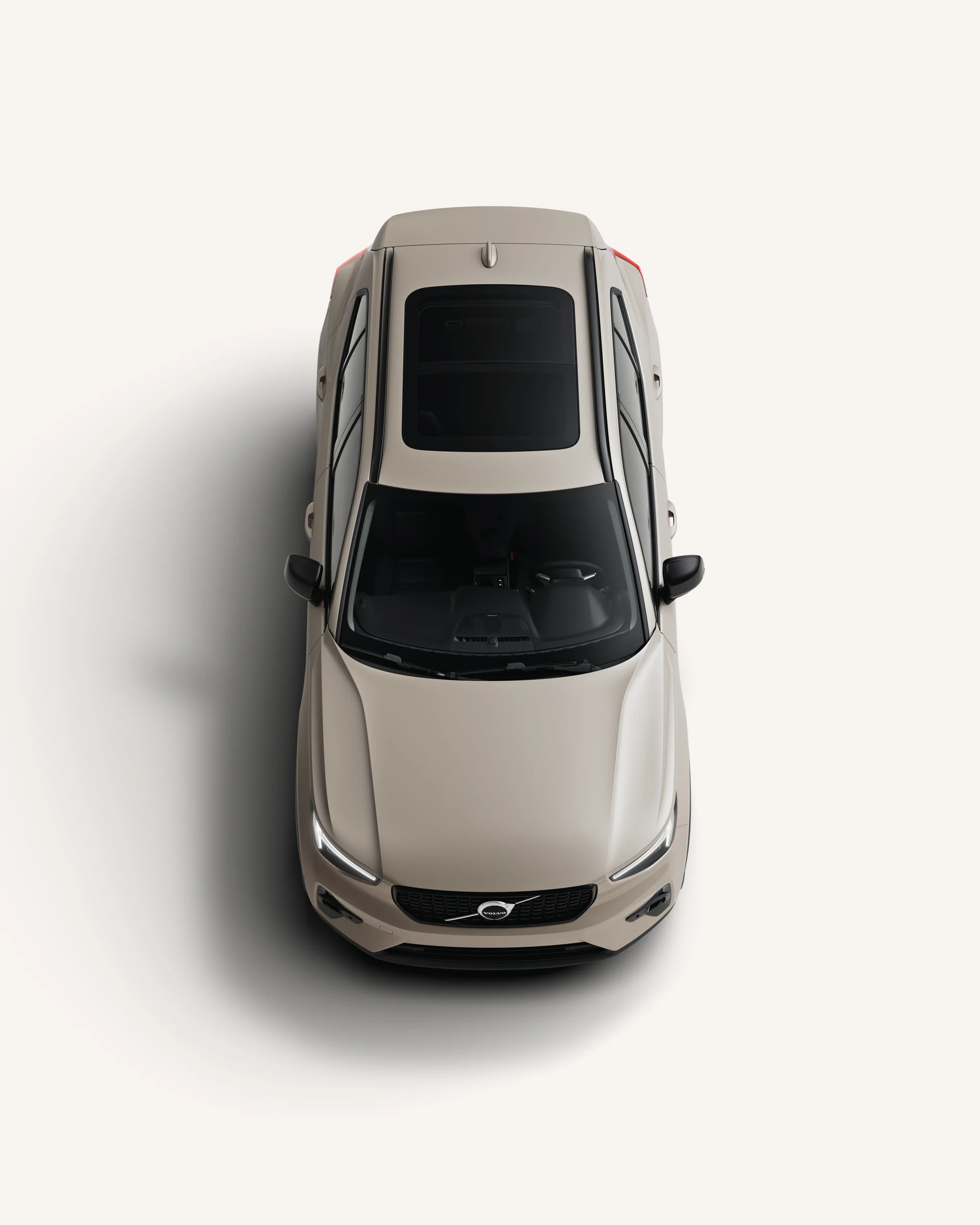 Вид сверху на мягкий гибридный внедорожник Volvo XC40 с крышей в белой студии.