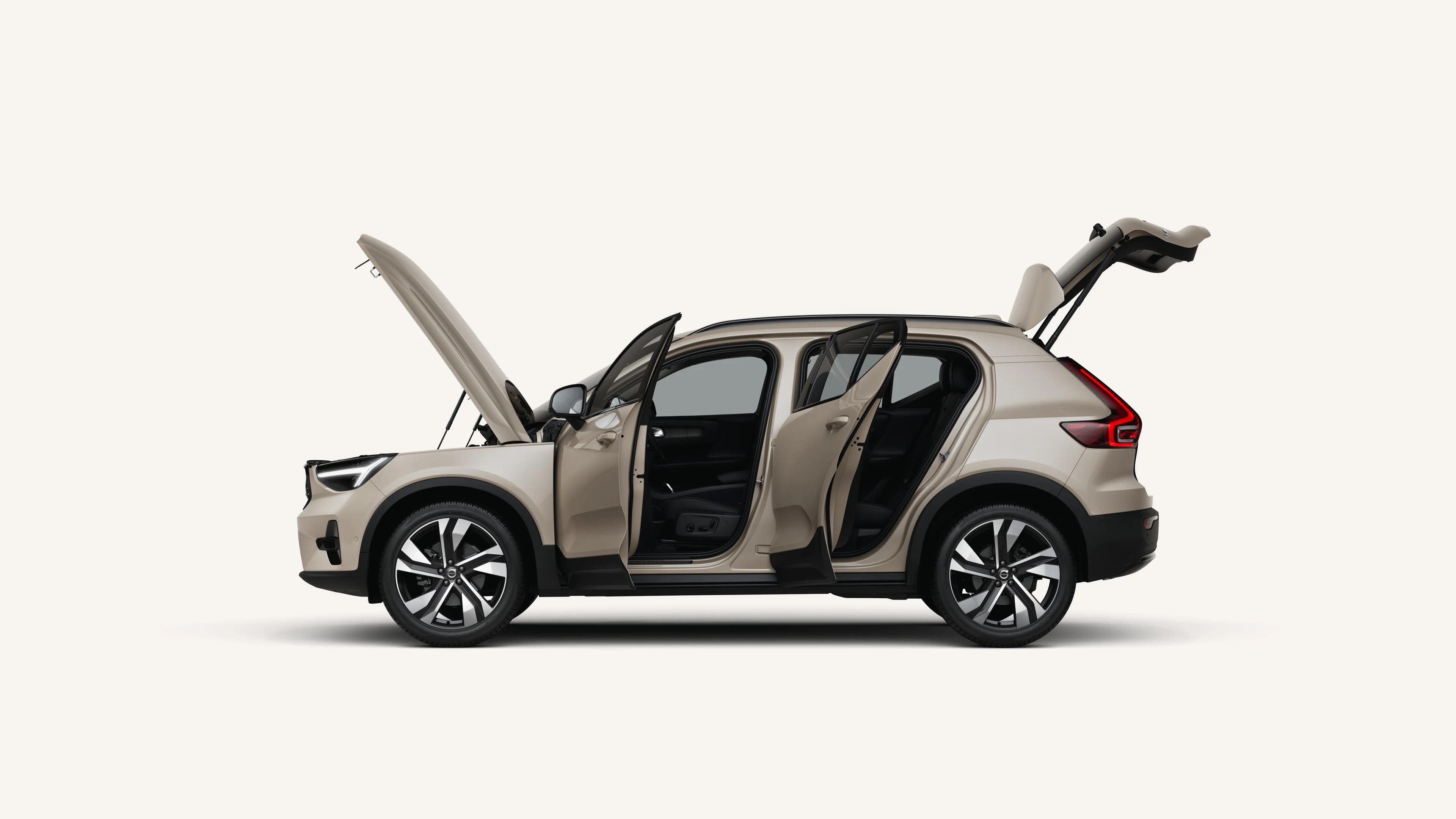 Вид сбоку на Volvo XC40 с открытым капотом, дверями и багажником в белой студии.