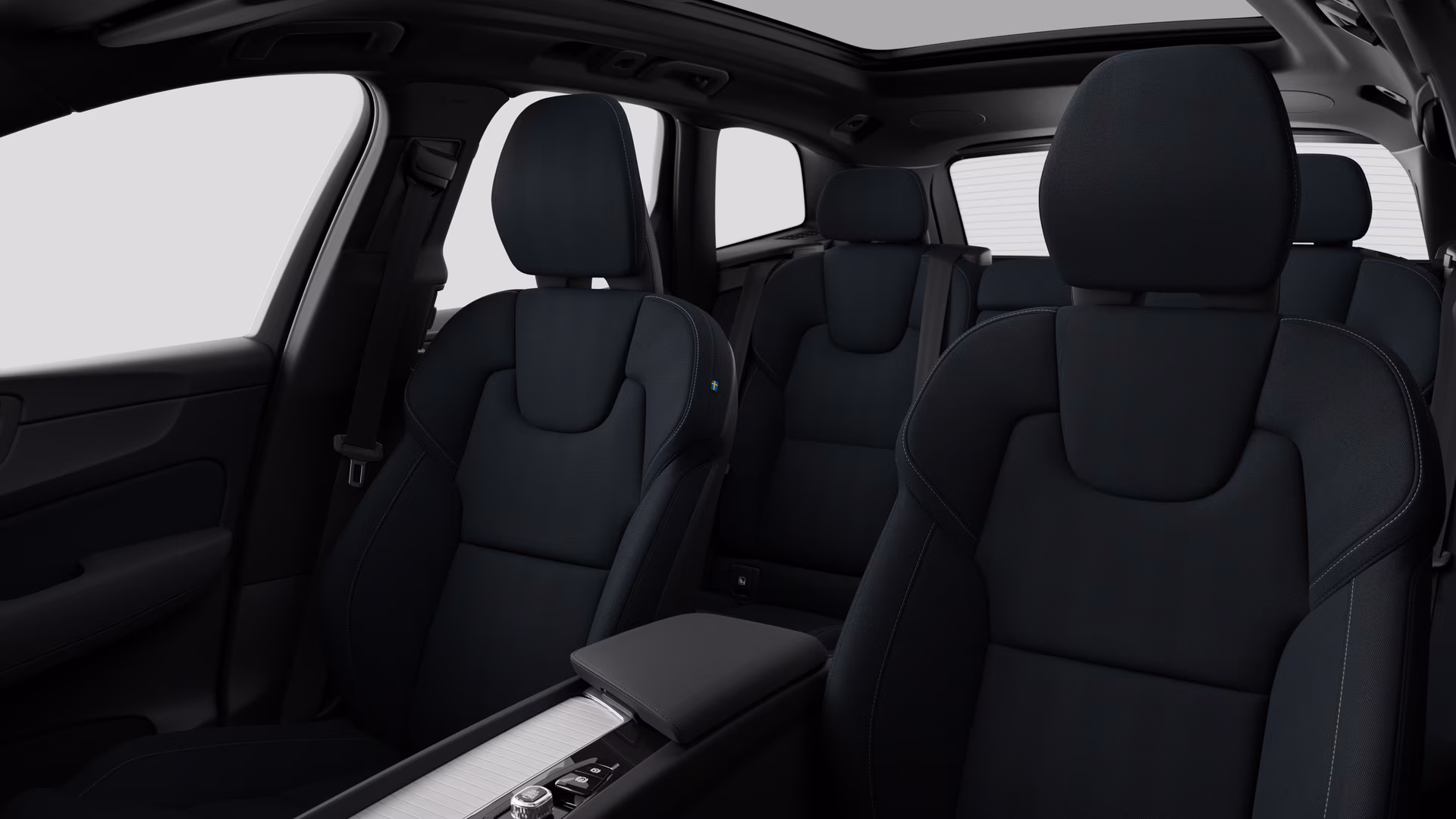Салон автомобиля Volvo с задними пассажирскими сиденьями и центральной консолью на простом фоне студии.