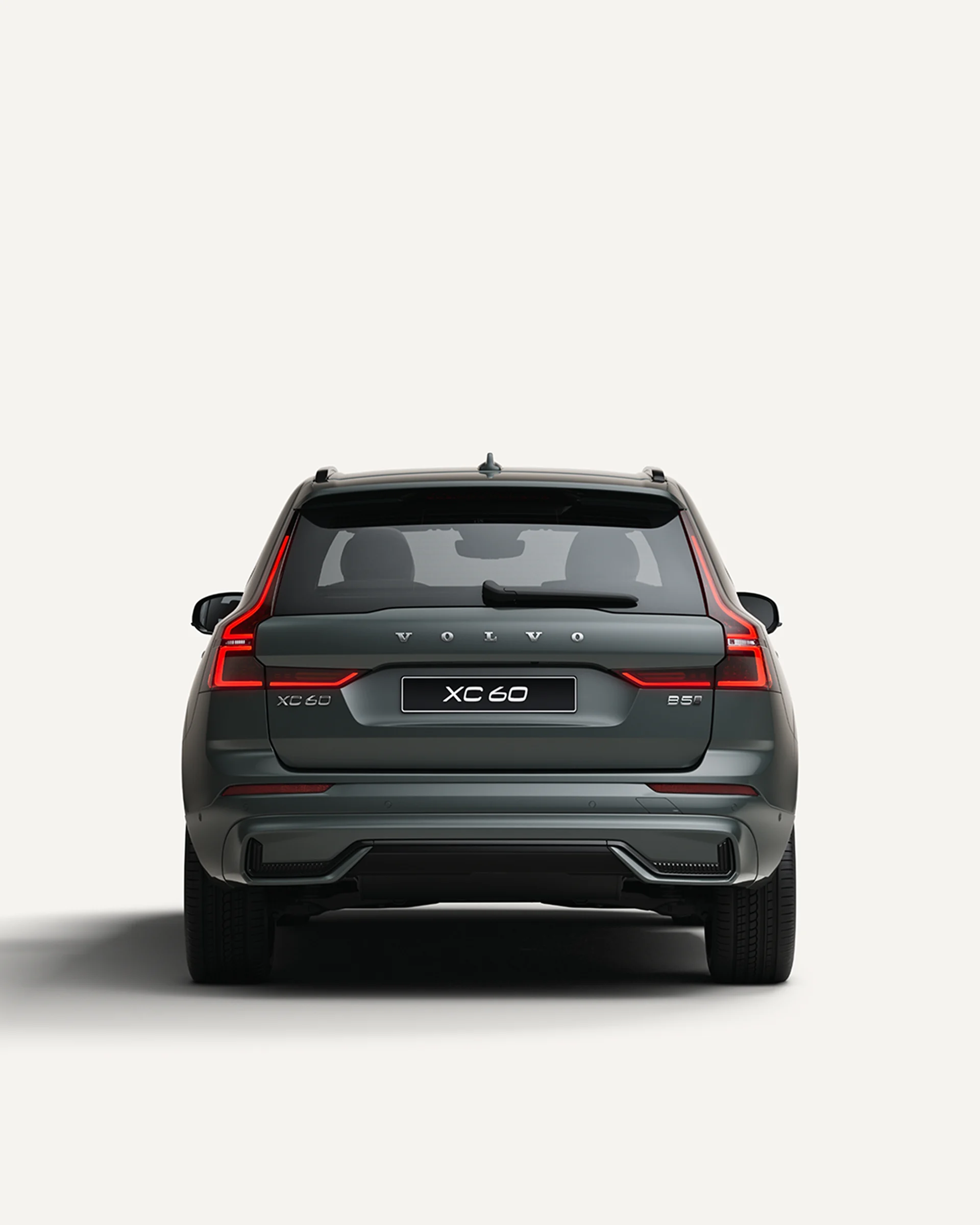 Вид сзади на среднеразмерный мягкий гибридный внедорожник Volvo XC60 в белой студии. 