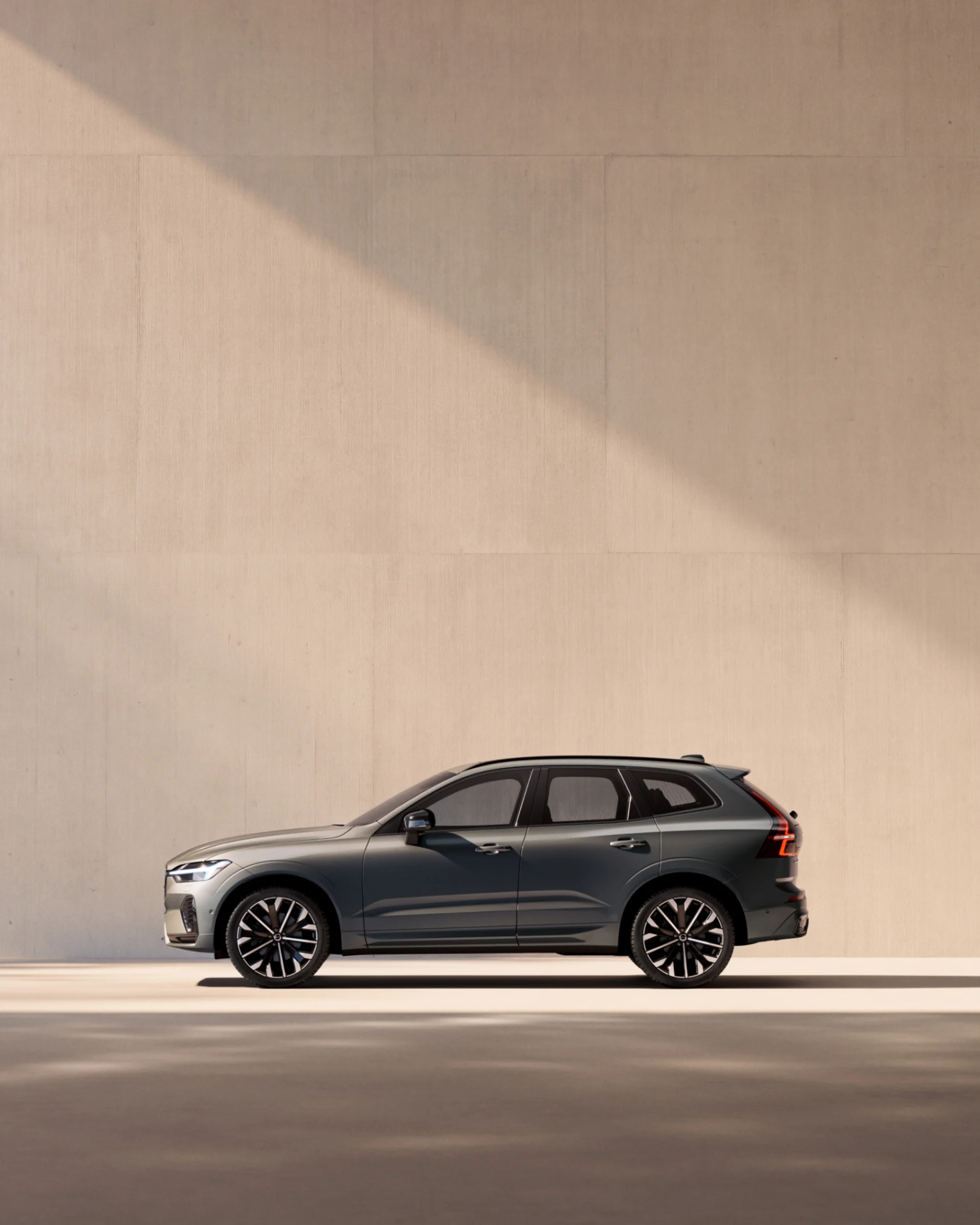 Вид сбоку на среднеразмерный мягкий гибридный внедорожник Volvo XC60 с профилированным дизайном и аэродинамическими колесами.