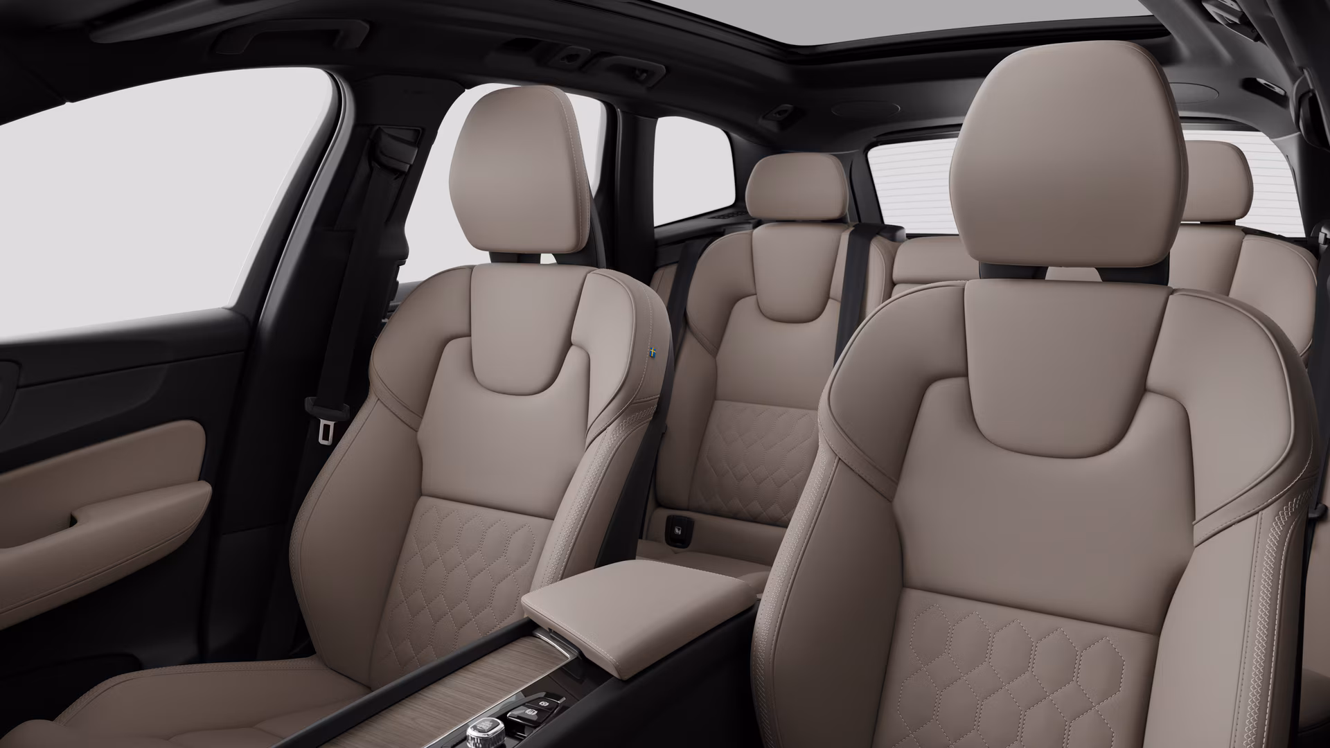 Салон автомобиля Volvo с задними пассажирскими сиденьями и центральной консолью на простом фоне студии.