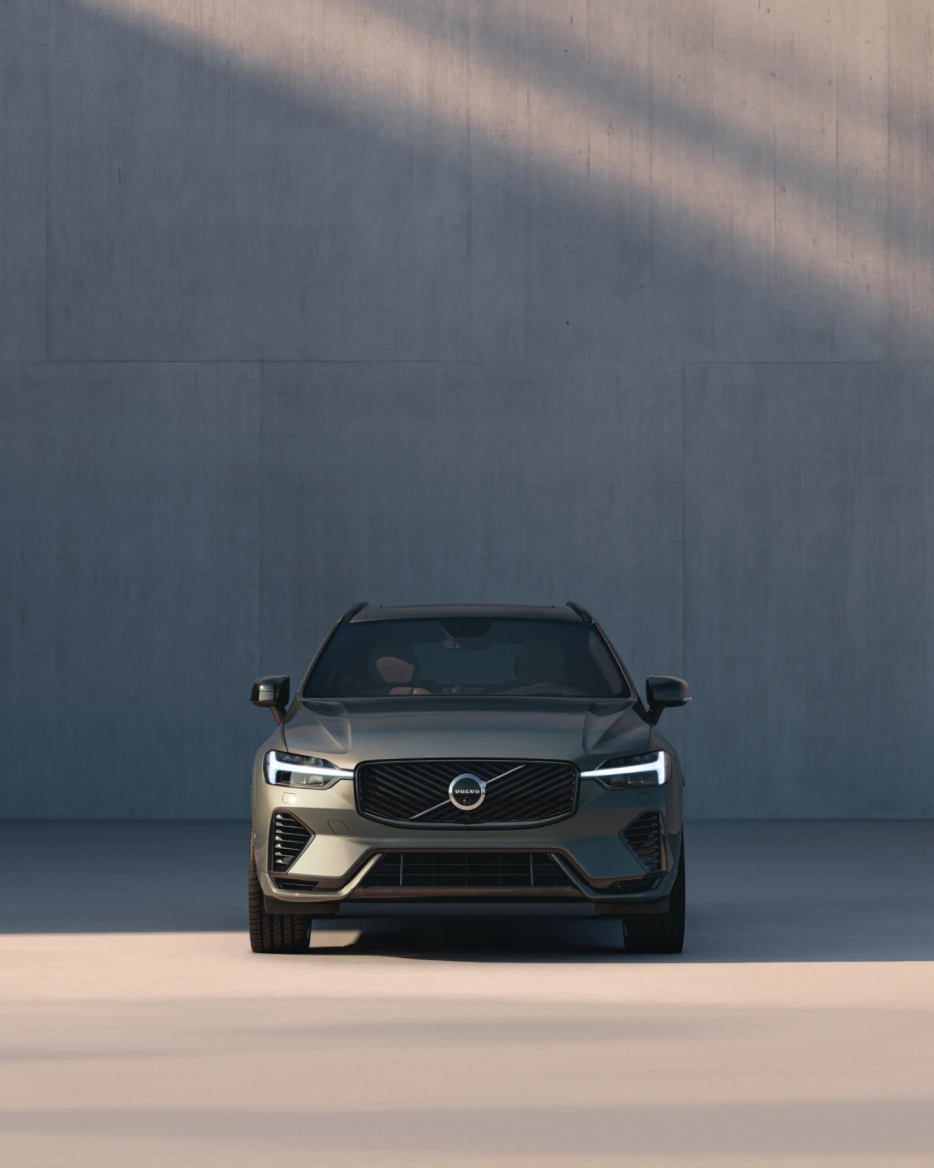 Вид спереди на среднеразмерный мягкий гибридный внедорожник Volvo XC60, передняя решетка радиатора и светодиодные фары.