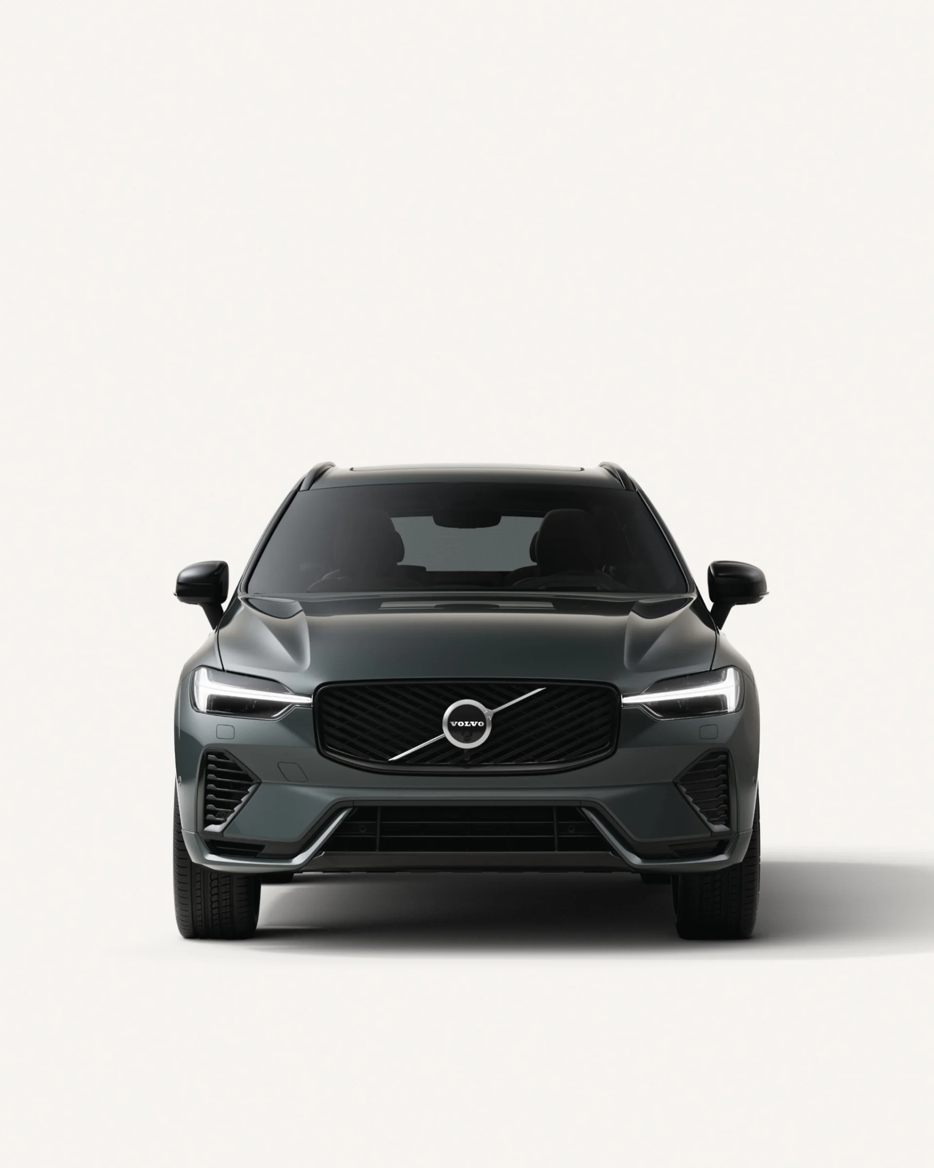 Вид спереди на среднеразмерный мягкий гибридный внедорожник Volvo XC60 в белой студии. 