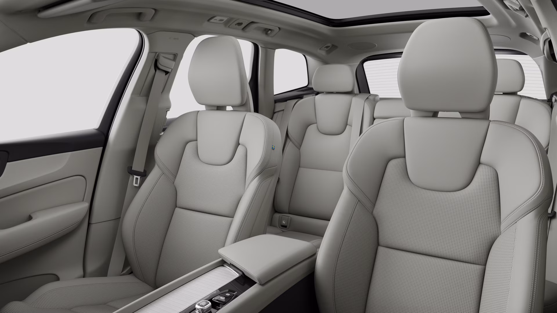 Салон автомобиля Volvo с задними пассажирскими сиденьями и центральной консолью на простом фоне студии.