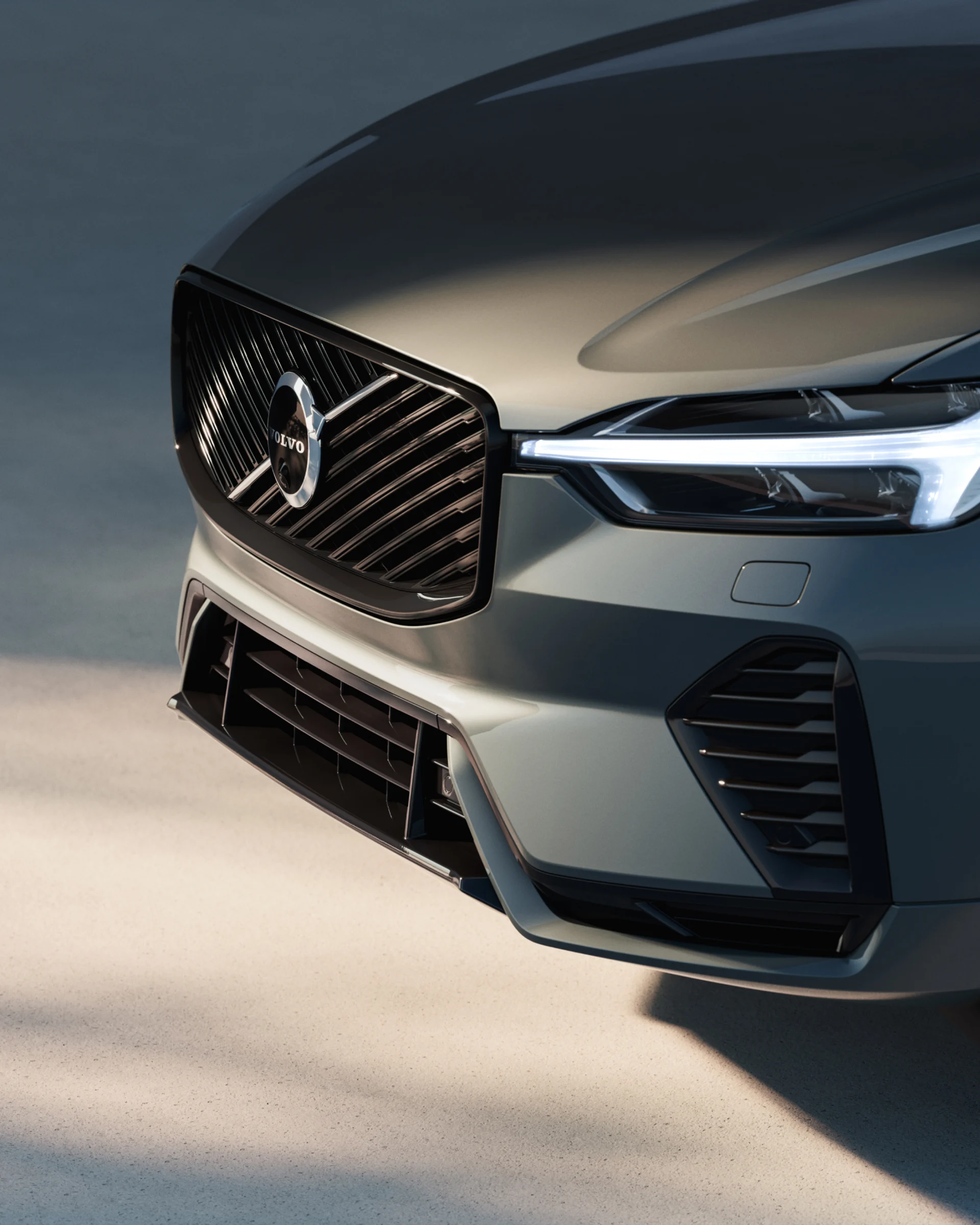 Передняя часть мягкого гибридного внедорожника Volvo XC60 с решеткой радиатора и светодиодными фарами.