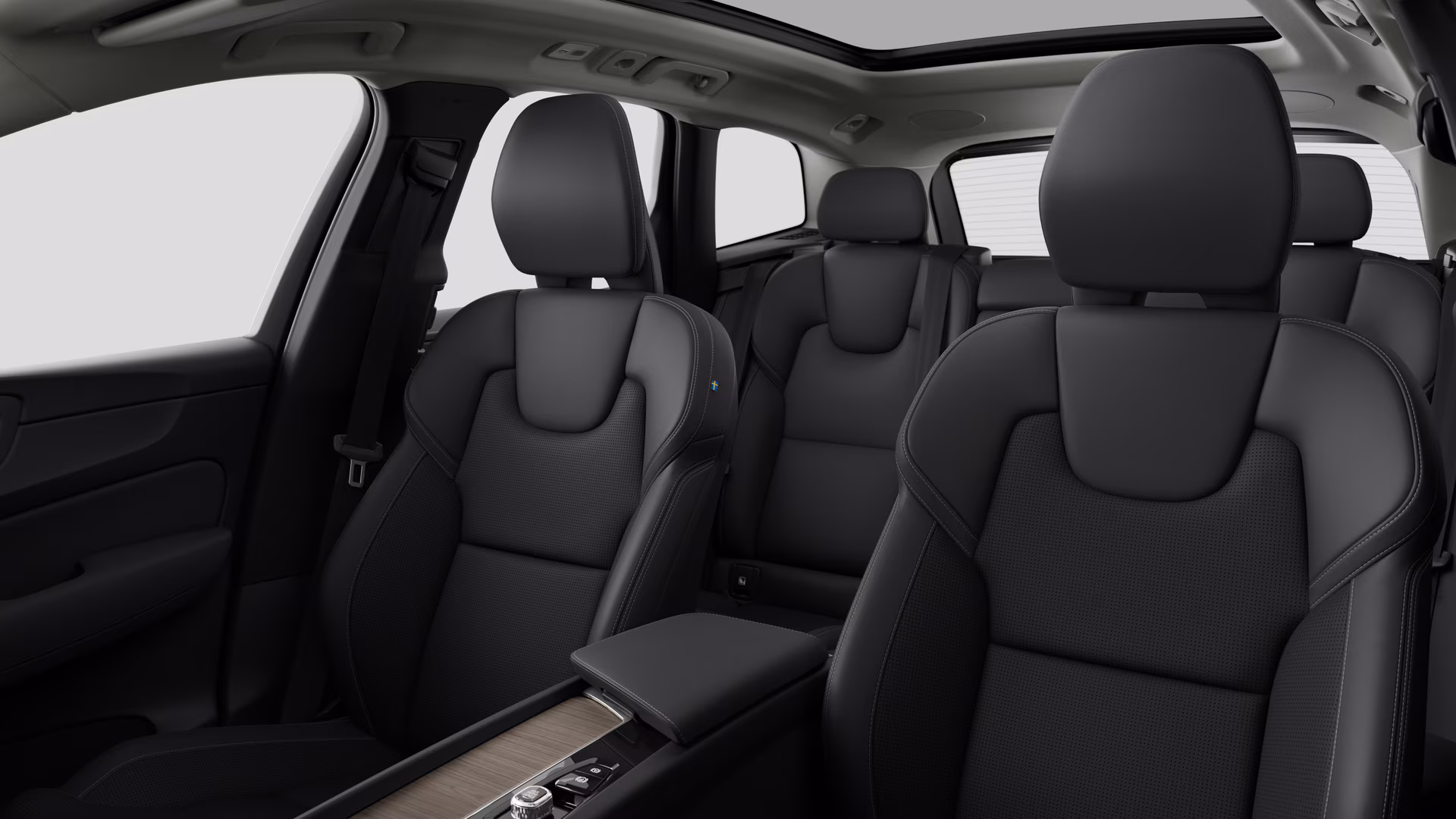 Салон автомобиля Volvo с задними пассажирскими сиденьями и центральной консолью на простом фоне студии.