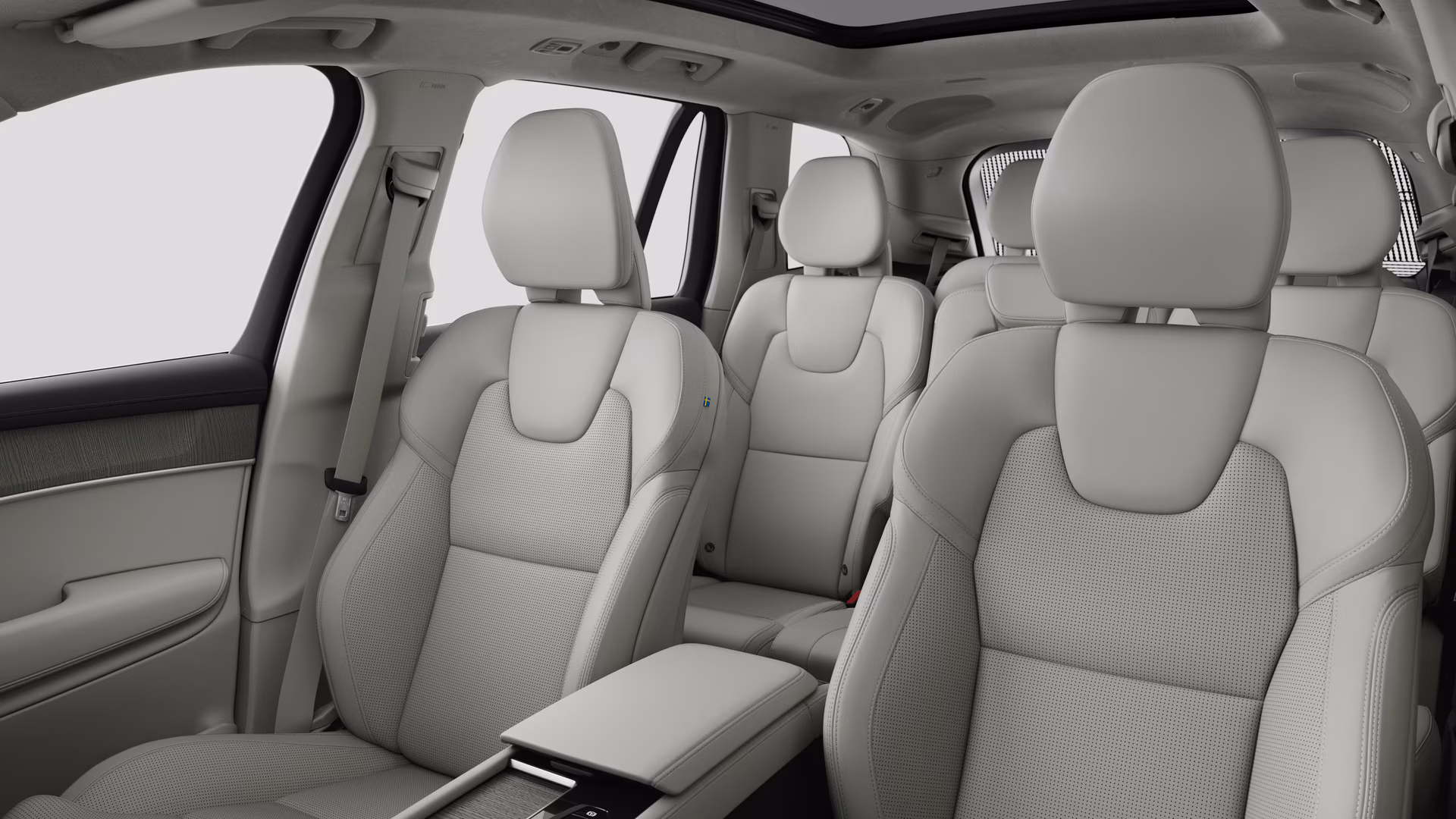 Салон автомобиля Volvo с задними пассажирскими сиденьями и центральной консолью на простом фоне студии.