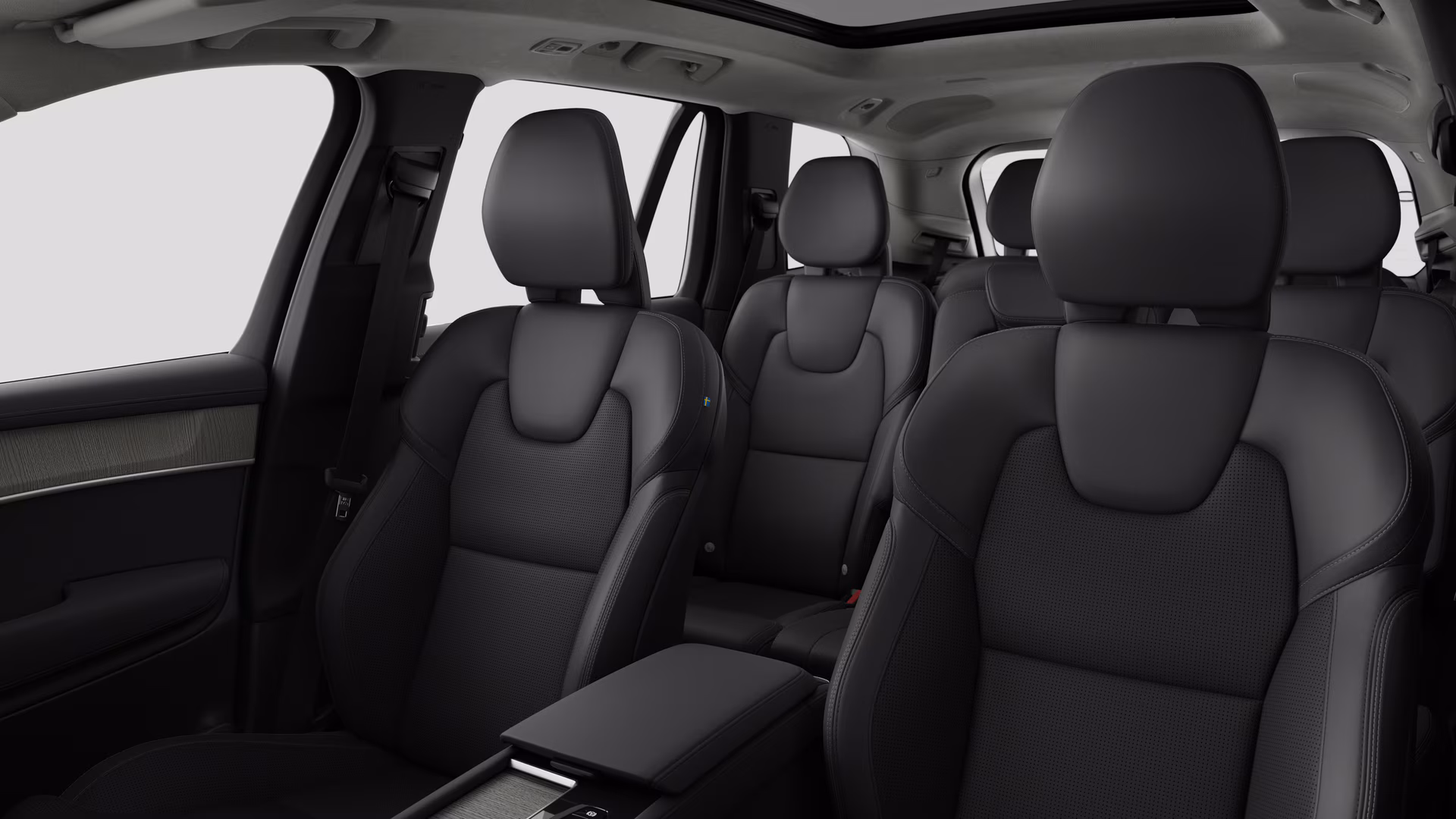 Салон автомобиля Volvo с задними пассажирскими сиденьями и центральной консолью на простом фоне студии.