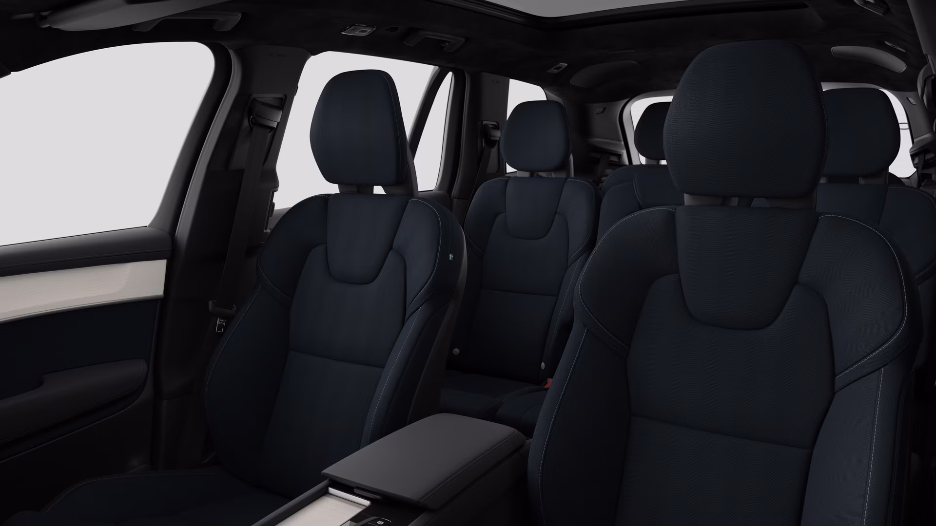 Салон автомобиля Volvo с задними пассажирскими сиденьями и центральной консолью на простом фоне студии.
