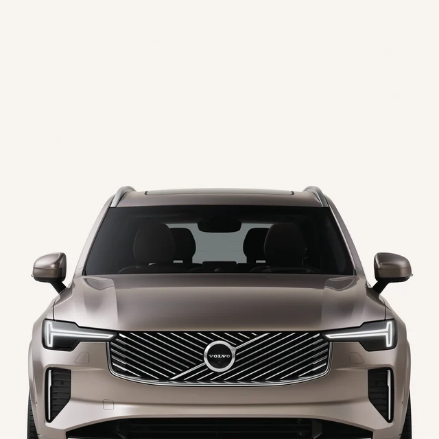 Вид спереди, демонстрирующий изысканную переднюю часть Volvo XC90 в белой студии. 
