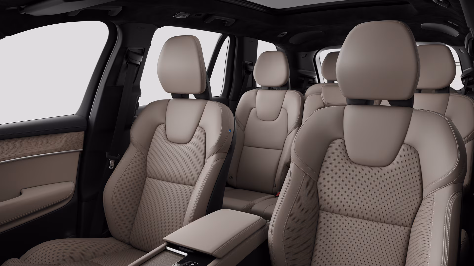 Салон автомобиля Volvo с задними пассажирскими сиденьями и центральной консолью на простом фоне студии.